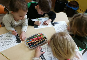 Dzieci rysują drogę w labiryncie.