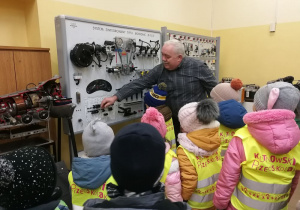 Pan, który był przewodnikiem na naszej wycieczce demonstruje dzieciom moment uruchamiania silnika w aucie.