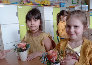 Lenka i Gabrysia prezentują wykonaną przez siebie kompozycję z kwiatów