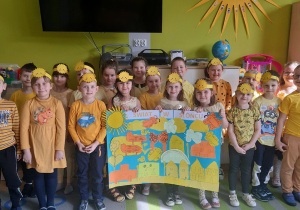 Przedszkolaki prezentują wykonany plakat pt. Świat w słońcu.