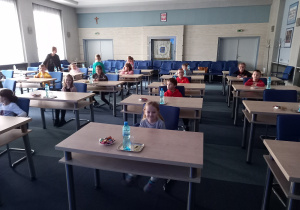 Dzieci siedzą przy stolikach na sali konferencyjnej w Urzędzie Miasta