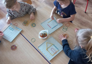 Dzieci układają figury za pomocą gumek
