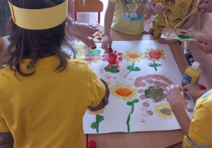 Dzieci malują farbami plakat "Świat w słońcu"