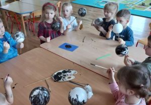 Dzieci malują styropianowe kule na czarno