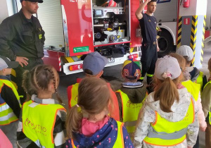 Przedszkolaki ogladają wyposażenie wozu strażackiego