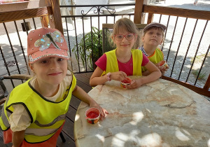 Kornelia, Paulina i Nadia siedzą na krzesełkach i jedzą lody