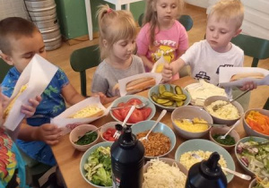 Dzieci przy stole pełnym zdrowych i kolorowych produktów