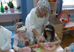 Pani Krysia jako Królowa Zimy uczy dzieci malowania obrazków na mleku