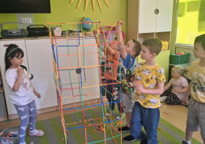 Dzieci konstruują budowle ze słomek konstrukcyjnych.