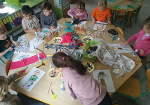 Dzieci projektują stroje z skrawków materiałów i guzików, które dostały od pani krawcowej.