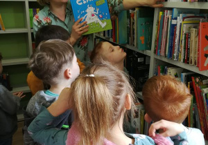 Dzieci oglądają półki z książkami.