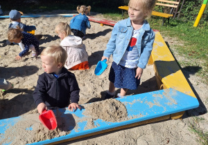 Julek i Klara bawią się w piaskownicy.