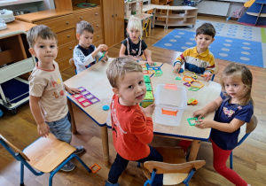 Dzieci bawią się klockami magnetycznymi przy stoliku.