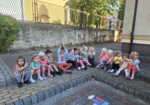 Dzieci siedzą na schodach na placu zabaw.