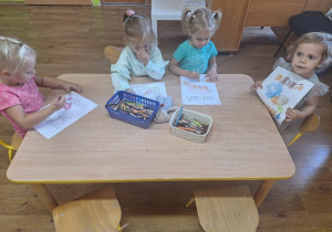 Dziewczynki kolorują obrazki konturowe tematycznie związane z Dniem Chłopca.