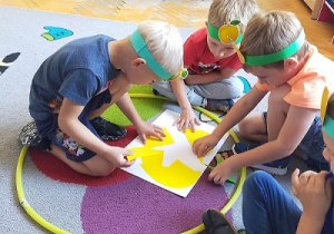 Dzieci układają puzzle żółtego jabłka