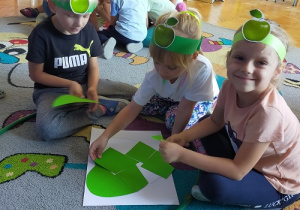 Dzieci z drużyny Zielone Jabłuszko układają puzzle jabłka
