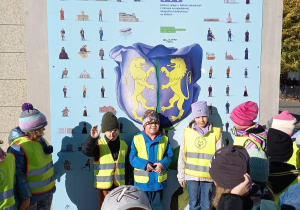 Dzieci pozują na tle herbu Kutna na ul. Królewskiej