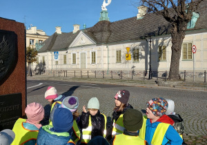 Dzieci pozują do zdjęcia na tle Pałacu Saskiego