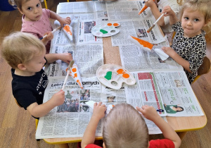 Dzieci malują farbami plakatowymi przestrzenne modele marchewek.