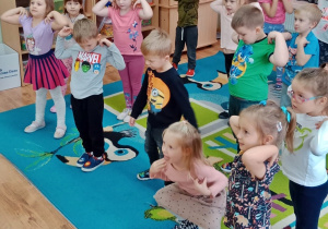 Dzieci wykonują okrężne ruchy ramionami.