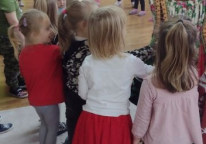 Tancerze prezentują dzieciom stroje krakowskie.