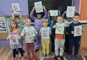 Dzieci prezentują kolorowanki do bajki "Masza i niedźwiedź"