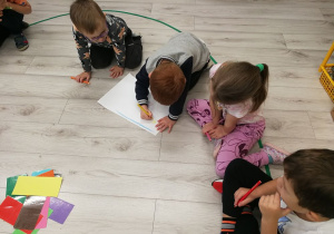 Dzieci rysują wspólny kolorowy obrazek.