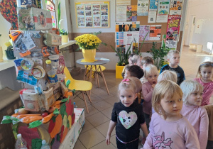 Dzieci oglądają Piramidę Zdrowego Żywienia i Aktywności Fizycznej, wykonaną z opakowań po produktach spożywczych, przeznaczonych do recyklingu.
