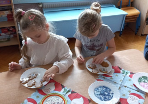 Lucynka, Klara i Kacper ozdabiają swoje pierniczki