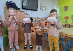 Dzieci zjadają miód z talerzyków.