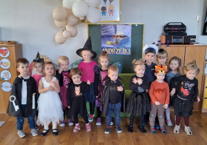 Dzieci przebrane w kostiumy andrzejkowe pozują do zdjęcia grupowego.
