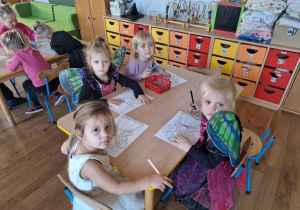 Dzieci kolorują obrazki konturowe tematycznie związane z Andrzejkami.