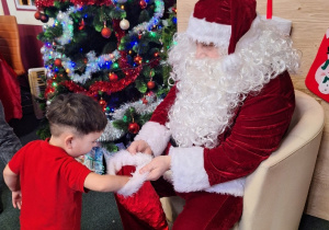 Maksio częstuje się cukierkiem od Świętego Mikołaja.