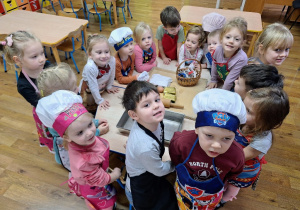 Dzieci poznają potrzebne akcesoria i produkty do pieczenia pierniczków.