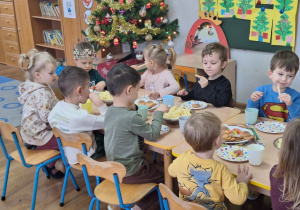 Franio siedzi z dziećmi przy urodzinowym stole.