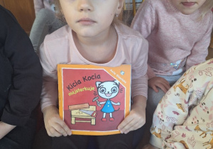 Oliwka prezentuje książeczkę "Kicia Kocia majsterkuje".