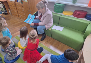 Pani Bibliotekarka czyta dzieciom książeczkę.