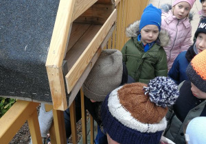 Dzieci wspólnie z tatą Alicji i Janka montują karmnik.