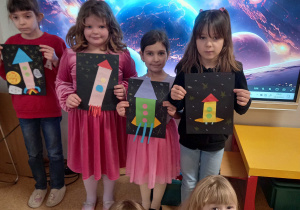 Dziewczynki prezentują swoje rakiety kosmiczne