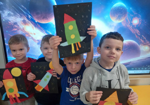 Chłopcy prezentują swoje rakiety kosmiczne