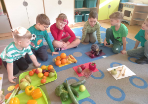 Dzieci układaja warzywa i owoce według kolorów