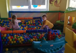 Dzieci w basenie z piłeczkami.