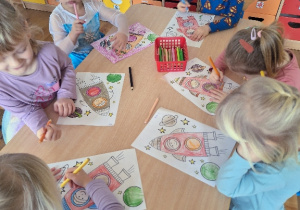 Dzieci kolorują obrazki konturowe pt. " Rakieta".