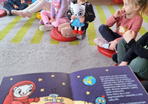 Dzieci słuchają książki "Kicia Kocia. W kosmosie".