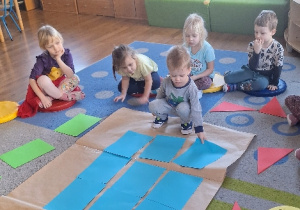 Dzieci układają rakietę z figur geometrycznych.