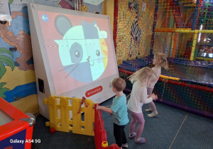 Dzieci grają w grę na tablicy interaktywnej.