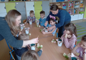 Dzieci z pomocą pani florystki komponują swoje bukieciki