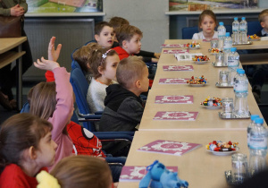 Dzieci siedzą w sali konferencyjnej podczas spotkania z prezydentem