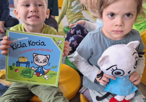 Jasio i Julianka prezentują maskotkę i książeczkę pt. "Kicia Kocia. Co zasiejemy w ogródku?".
